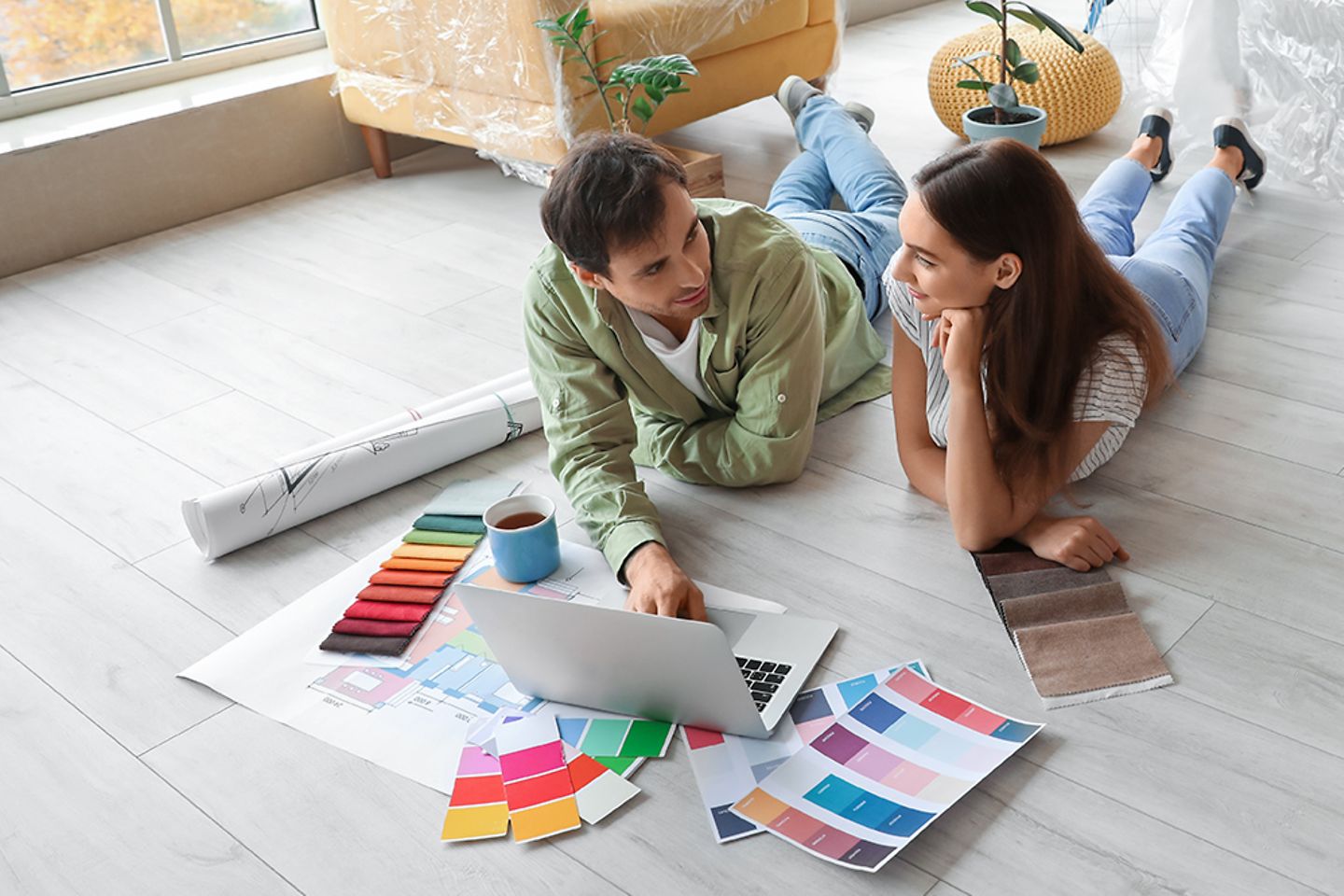 Junges Paar renoviert Wohnung, wählt online Bodenbelag und Wandbekleidung aus.