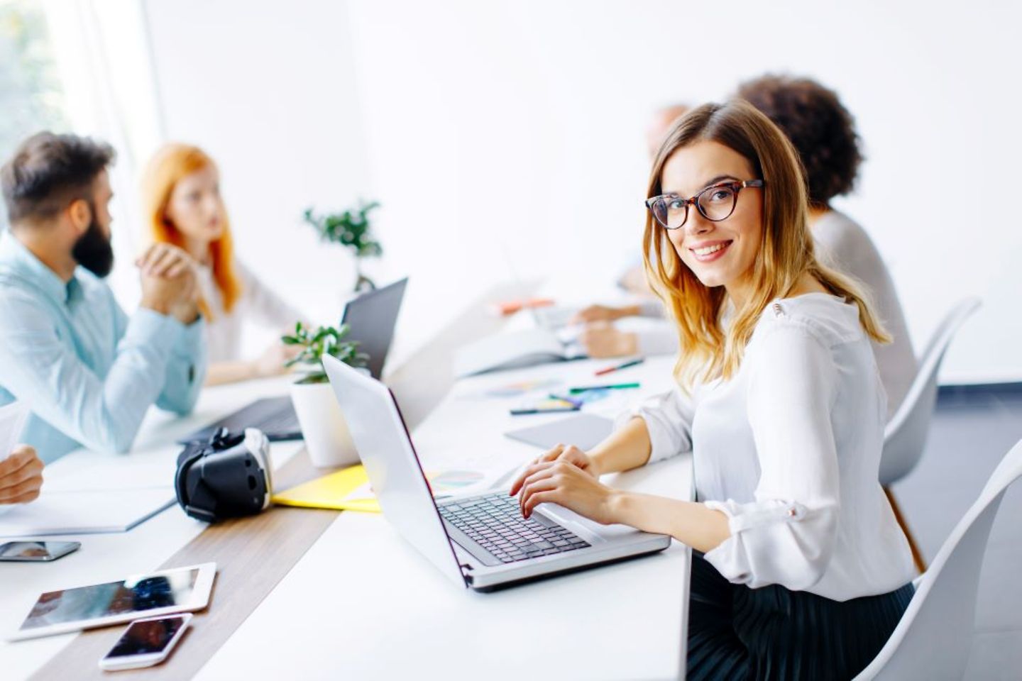 Funcionária sorridente da T-Systems com laptop