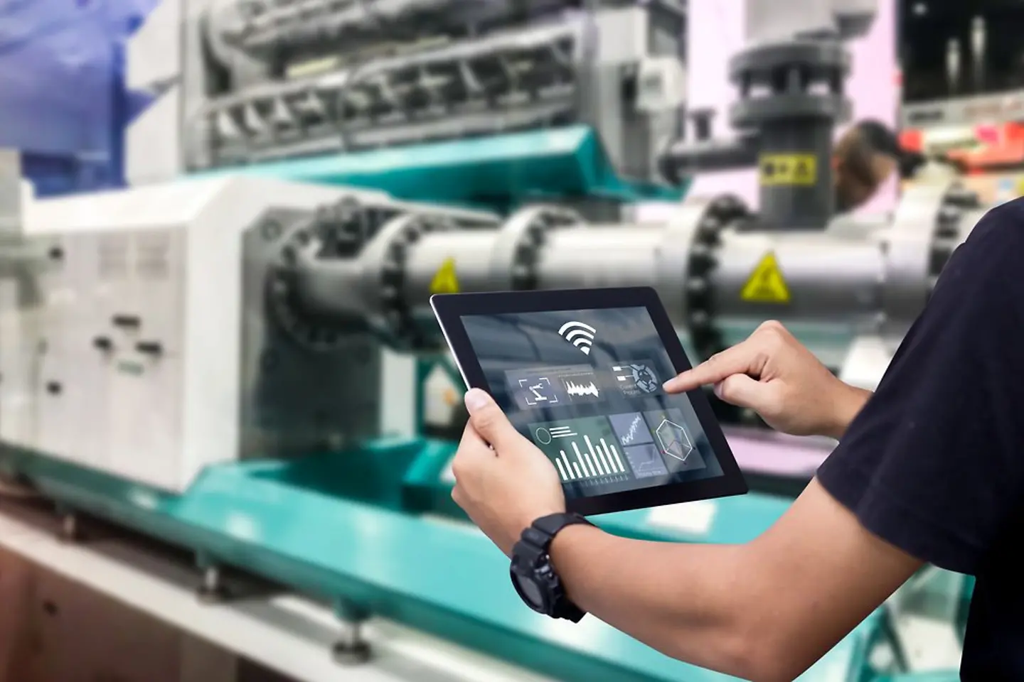 Manos sosteniendo la tableta en la máquina de automatización borrosa como fondo