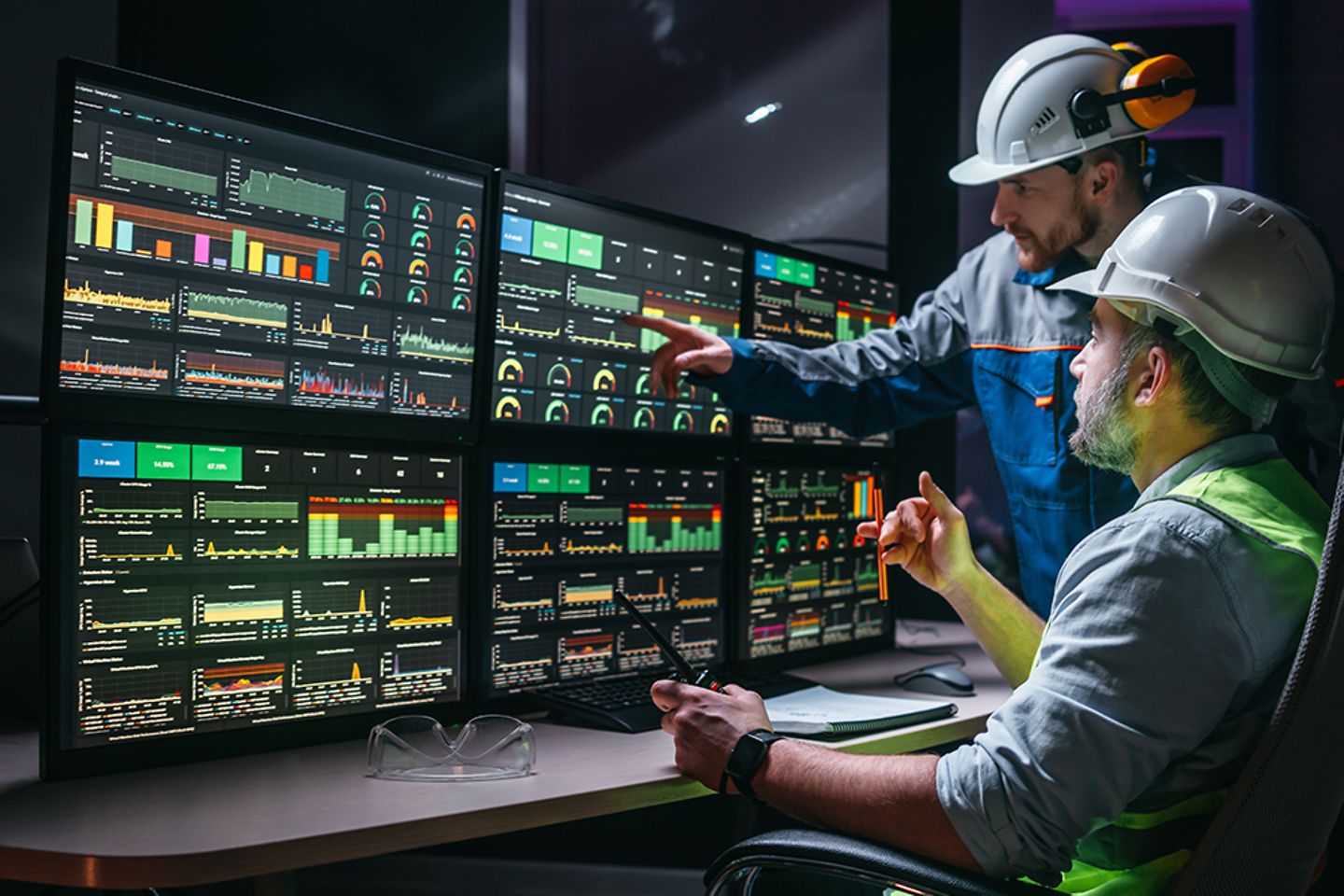 Leitender Ingenieur und Arbeiter, die Fabrikproduktionslinie an Bildschirmen mit Industrie-4.0-Software verfolgen. 