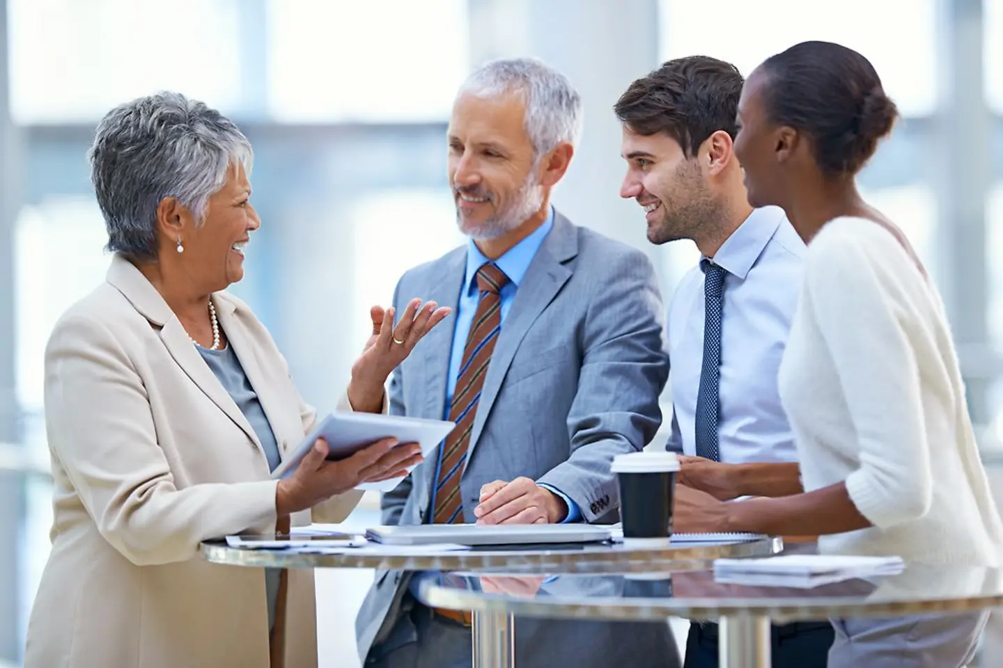 Business Partner verschiedener Nationen diskutieren miteinander am Stehtisch