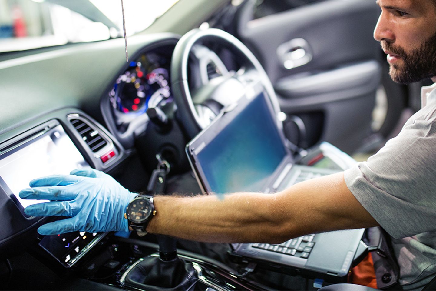 Un ingénieur en mécanique travaillant sur l’électronique dans une voiture