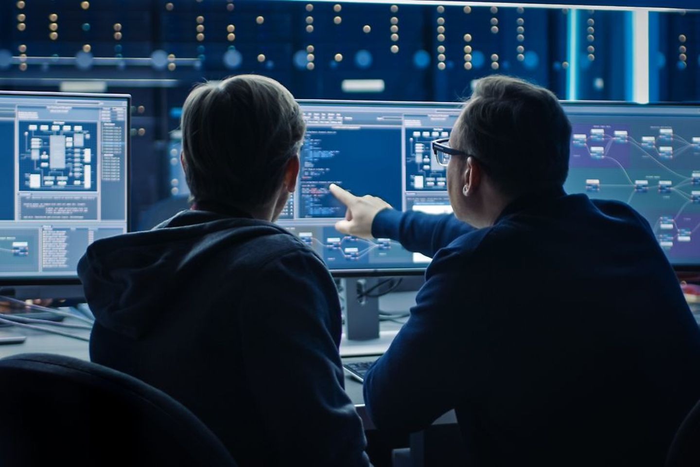 Zwei Softwareexperten betrachten eine Datenanalyse auf einem Computerbildschirm