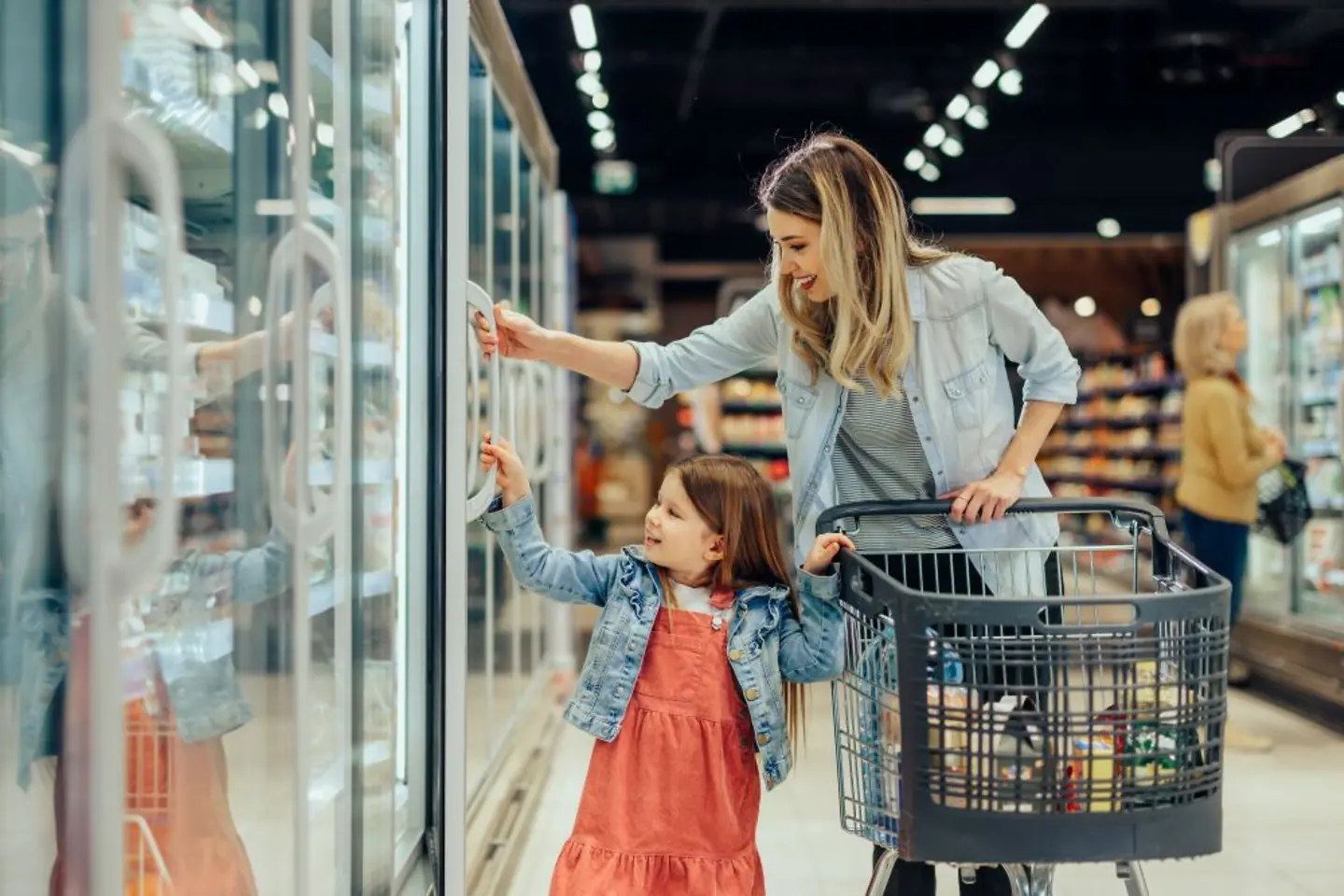 Klant met kind aan het winkelen in een kruidenierswinkel