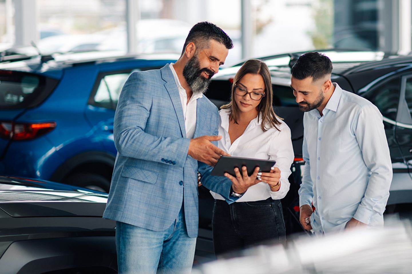 Un concessionnaire utilise une tablette pour améliorer le processus d’achat d’une voiture par un couple.
