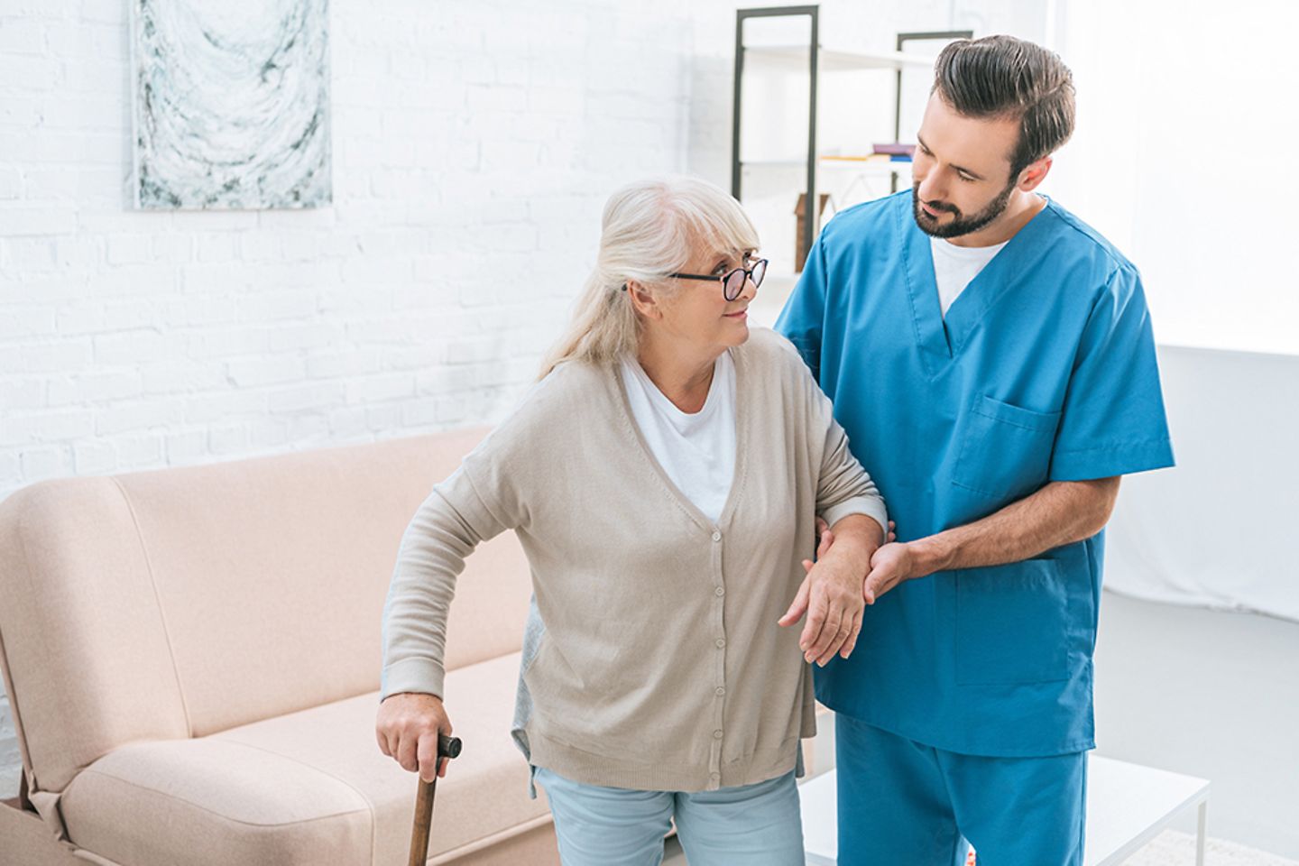 Enfermera apoyando a una anciana en un hospital