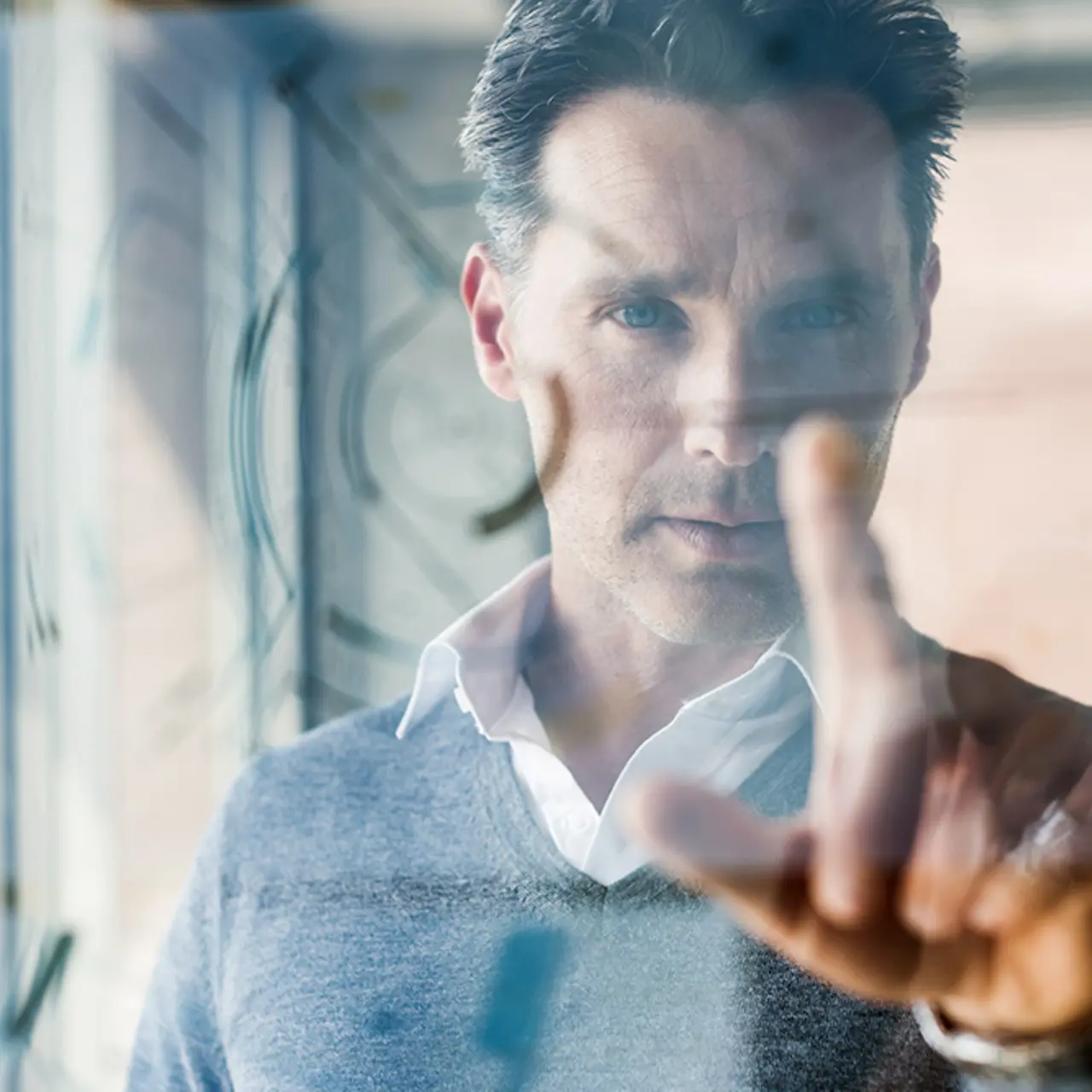 Geschäftsmann berührt transparente Projektionsfläche