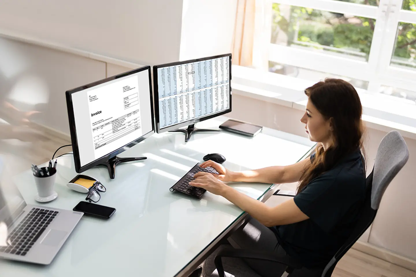 Eine Buchhalterin verwendet eine Software für elektronische Rechnungen auf einem Desktop-Computer