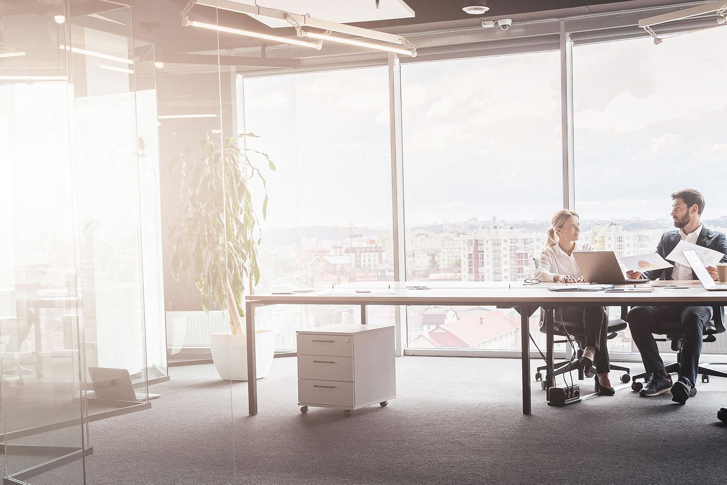 Geschäftsleute arbeiten an einem Projekt in einem modernen Büro mit Panoramablick