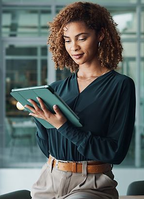 Female office worker in office accessing data on tablet