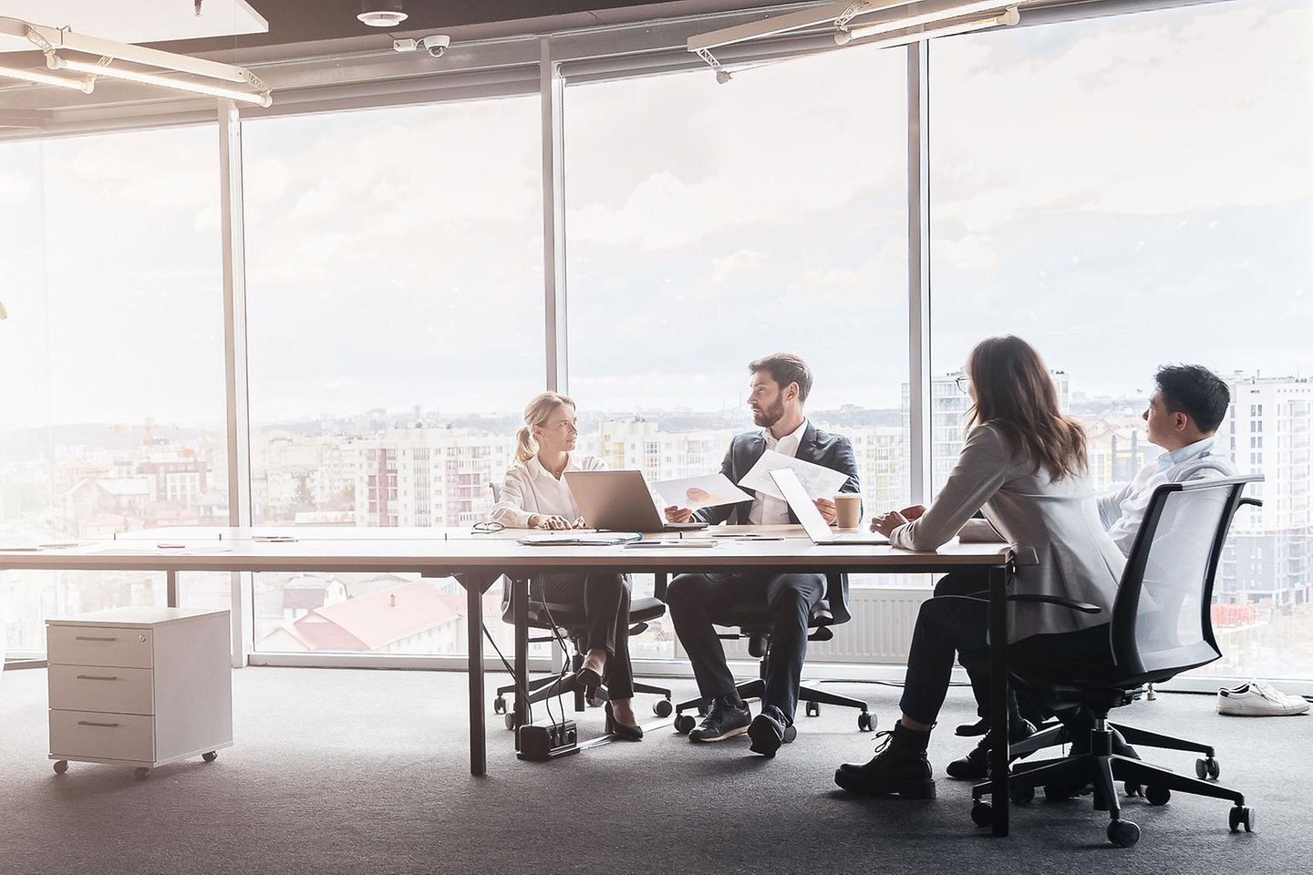 Geschäftsleute arbeiten an einem Projekt in einem modernen Büro mit Panoramablick