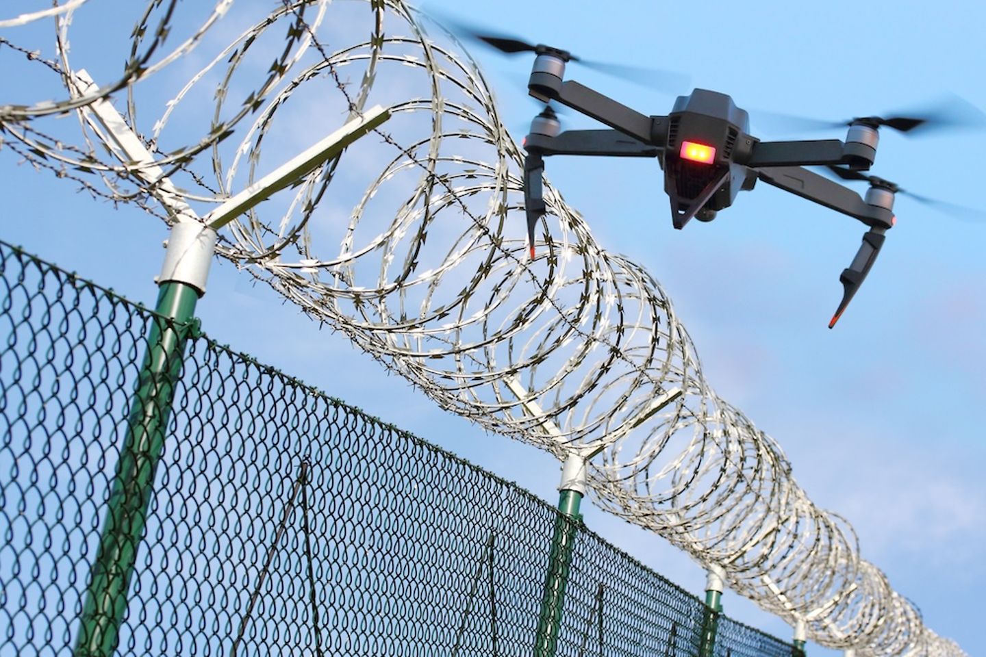 Drone vliegt over een beveiligd hek