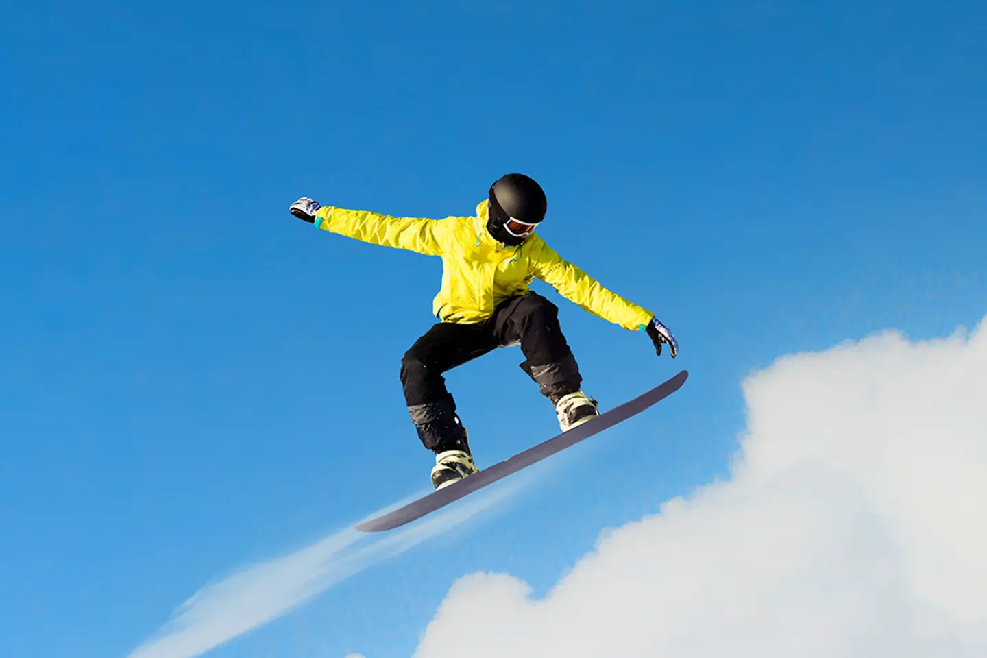 Snowboarder saltando con nubes de fondo
