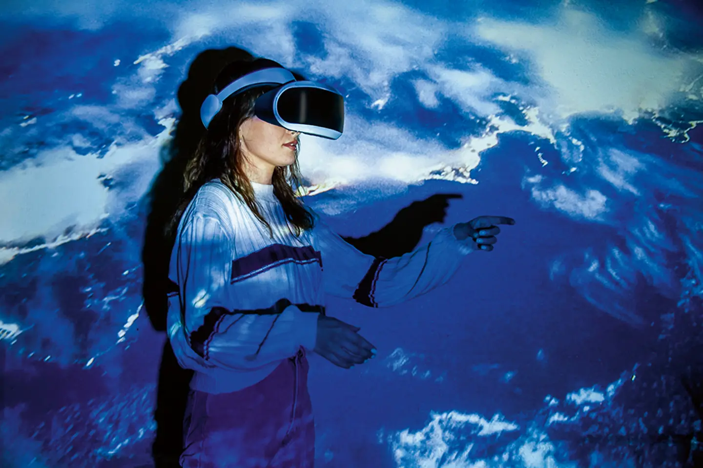Frau erkundet virtuelle Realität vor blauem Hintergrund