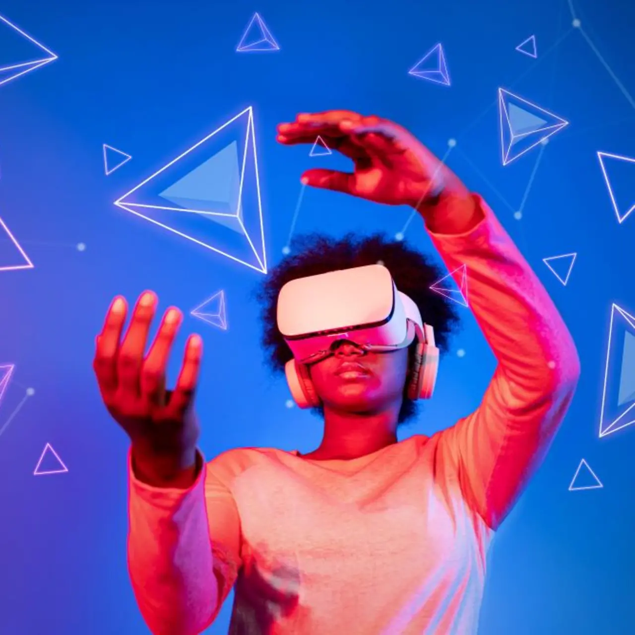 Une femme portant des lunettes de réalité virtuelle sur un fond bleu et rose observe des formes géométriques flottantes
