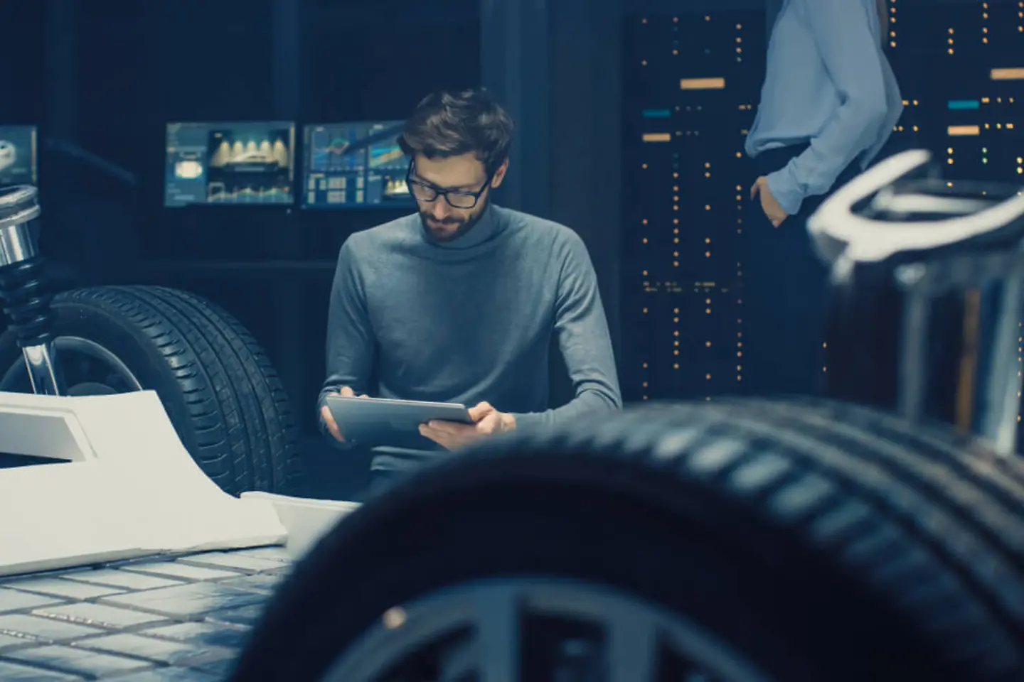 Un diseñador de automóviles trabaja junto al chasis de un vehículo eléctrico
