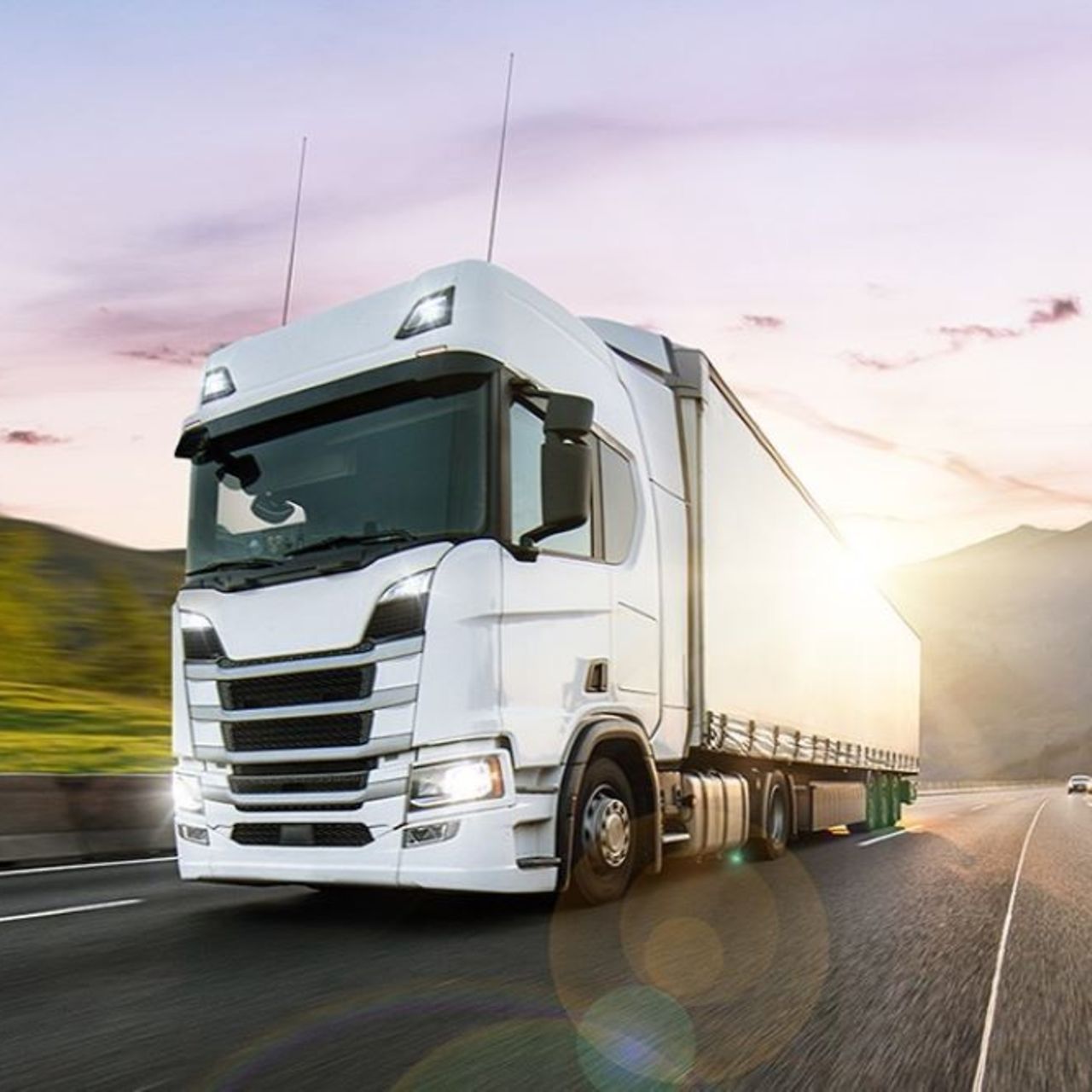 White truck driving in the sunset on a motorway 