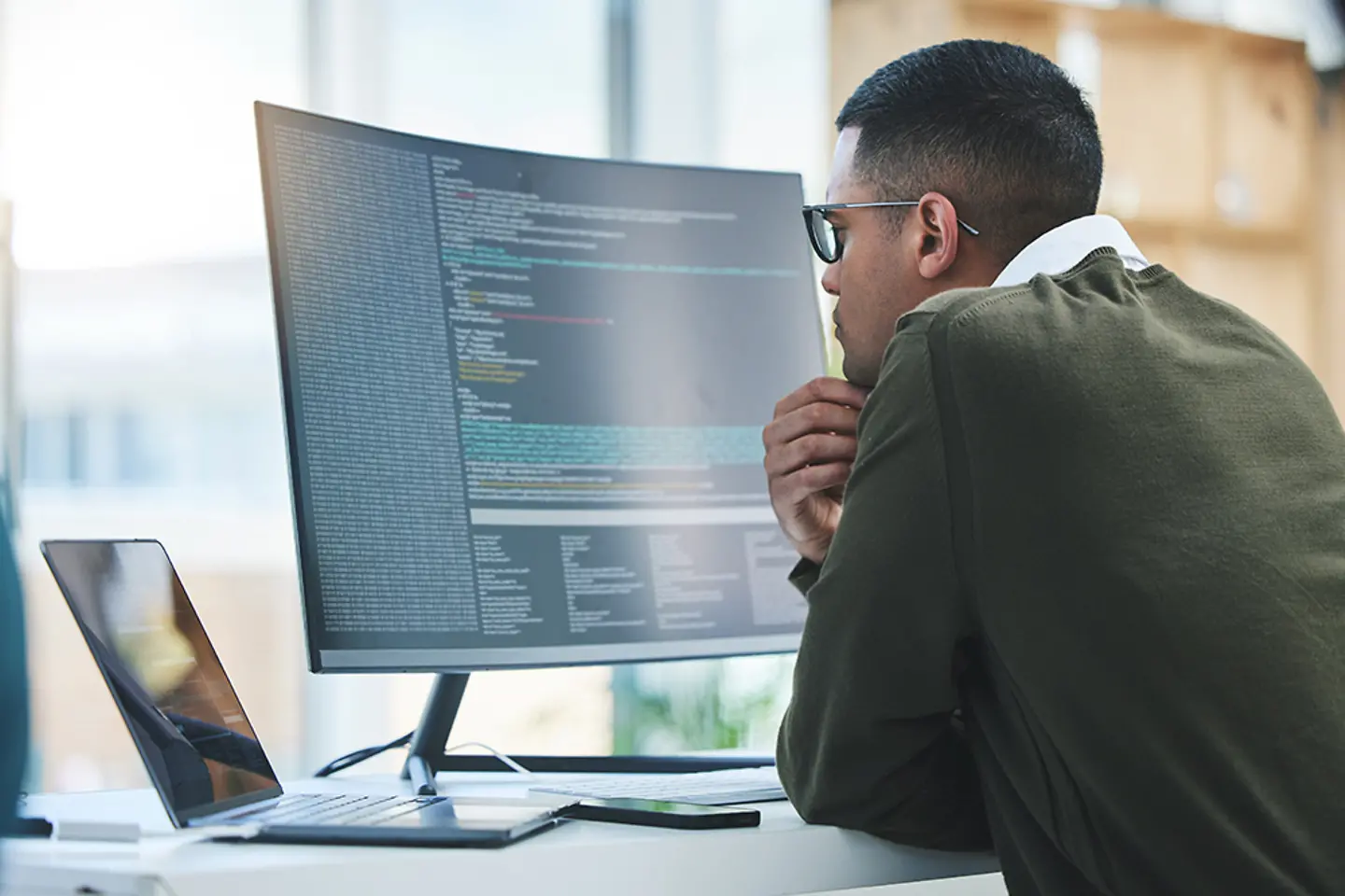 Man in front of computer screen working on software development