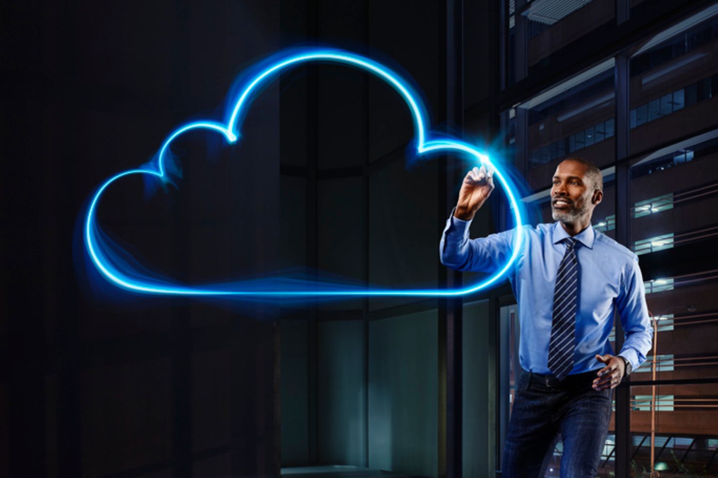 A man in a suit paints a virtual representation of the cloud with light.