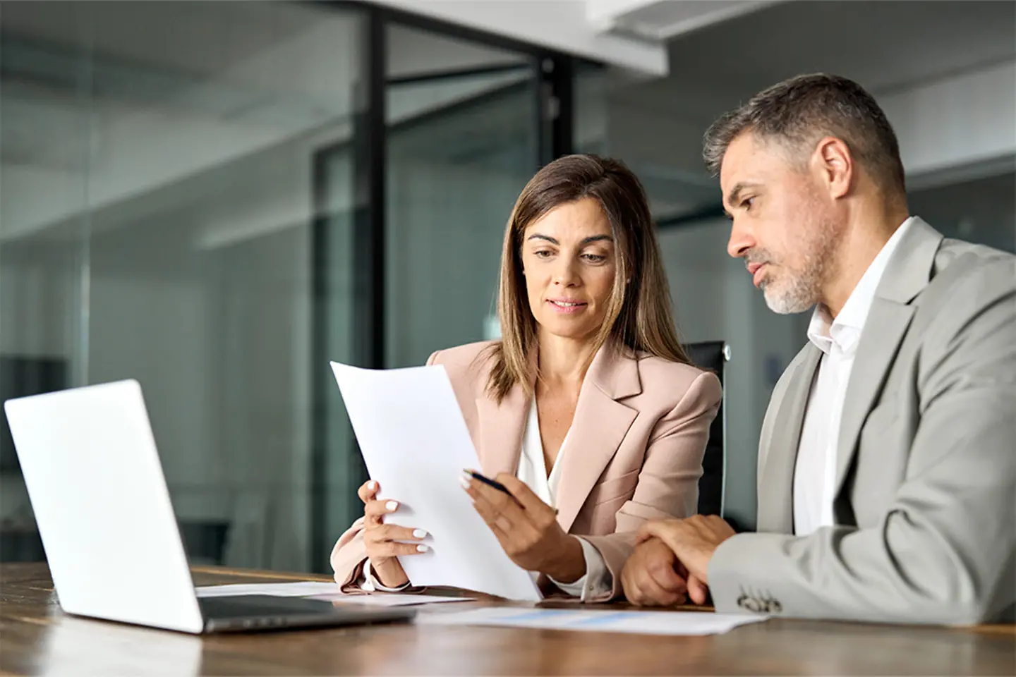 Professionals holding legal documents in office meeting.