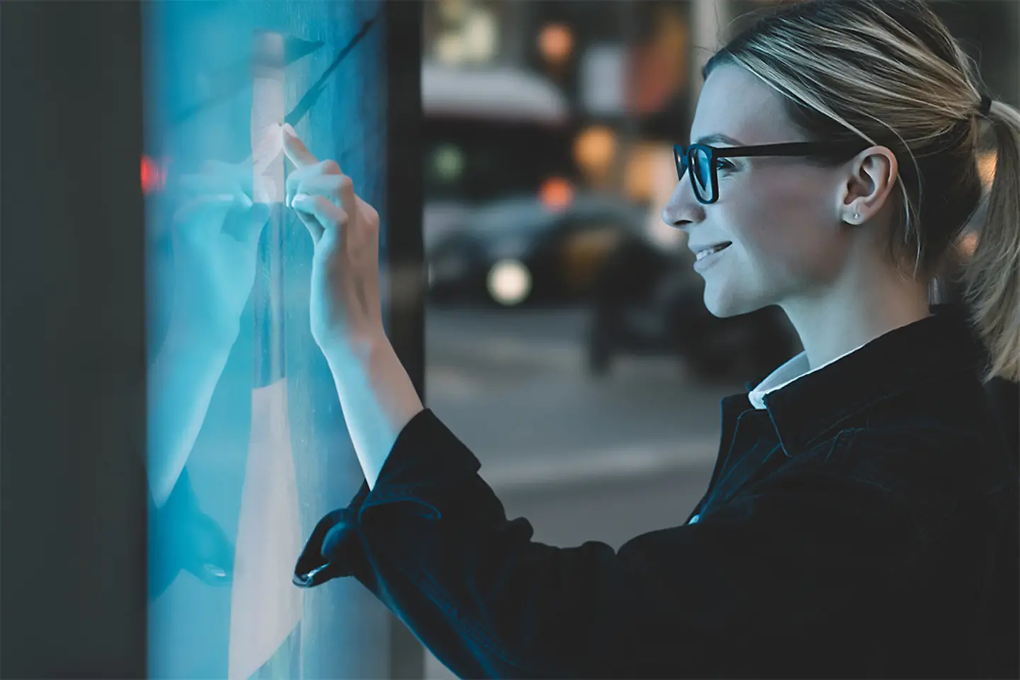 Mujer joven tocando una pantalla táctil con el dedo