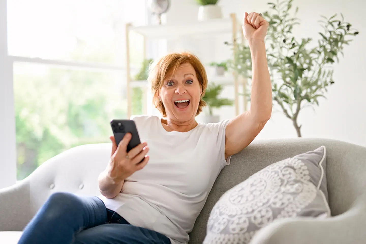Mulher animada com um smartphone na mão.