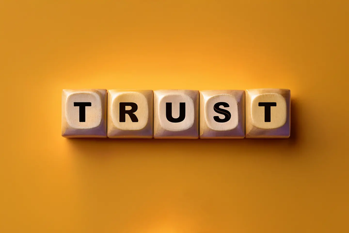 Trustworthy Artificial Intelligence Five dice on a yellow background with the letters TRUST