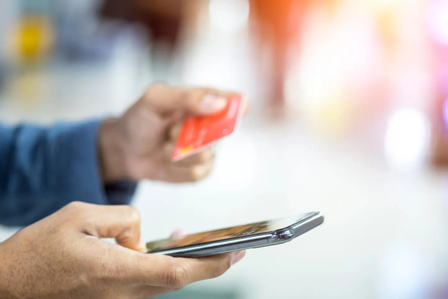 Primeros planos, manos de jóvenes sujetando tarjetas de crédito y usando móvil, smartphone, para comprar online