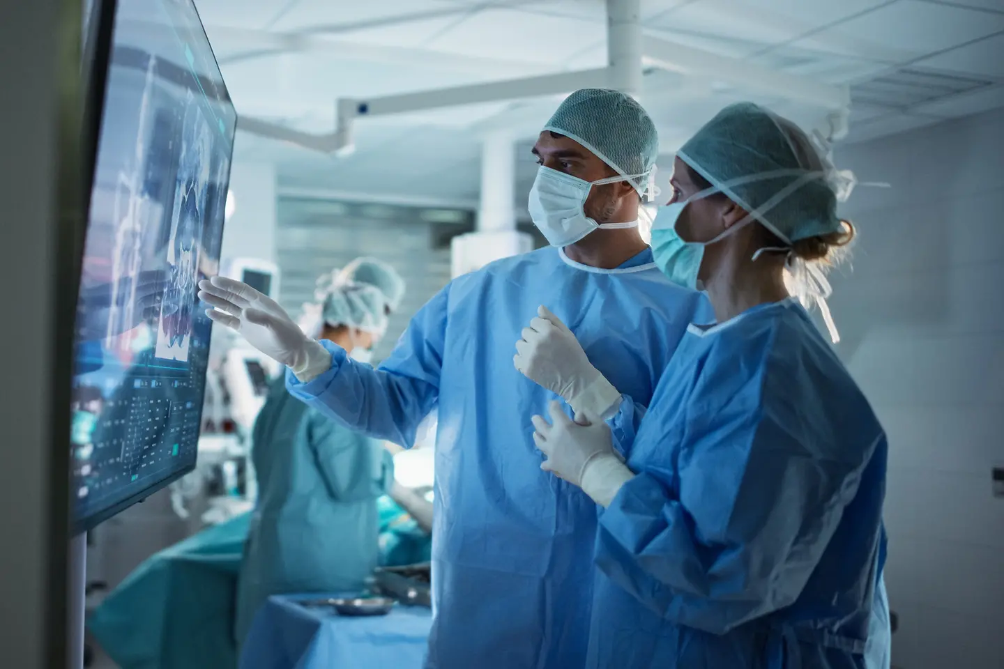 Surgeons Analyze Scans on a Digital Monitor, Planning Surgical Strategy in a High-tech Operating Room