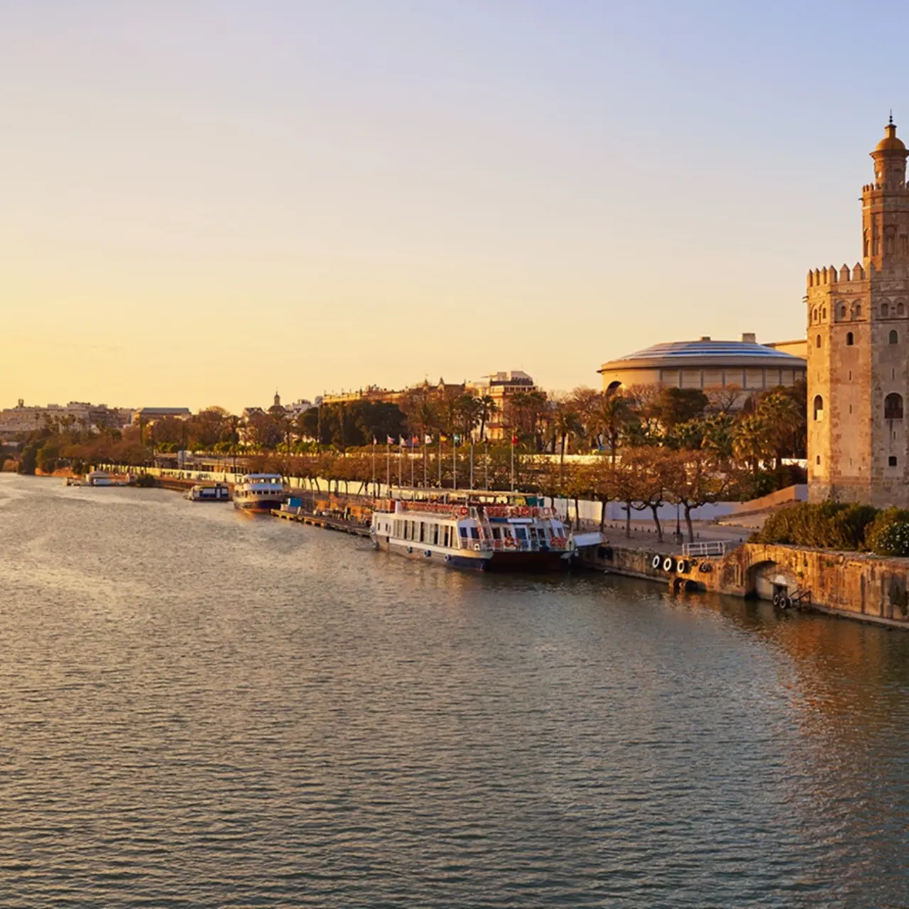 Puesta de sol sobre el perfil urbano de Sevilla: la Torre del Oro en Sevilla