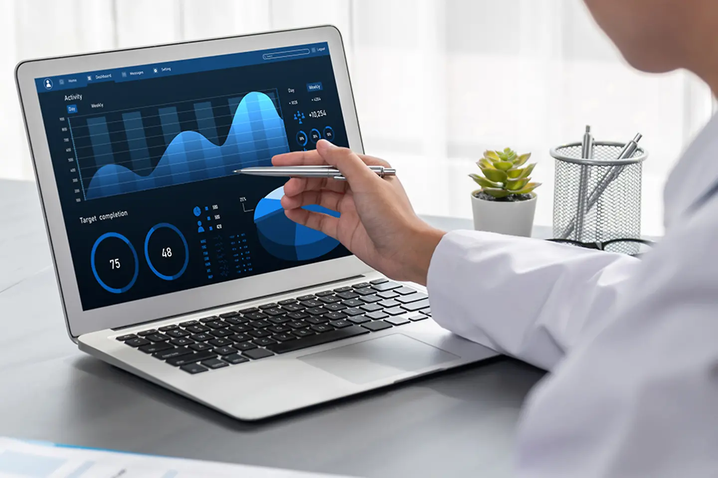 Female doctor pointing at a laptop screen with various diagrams