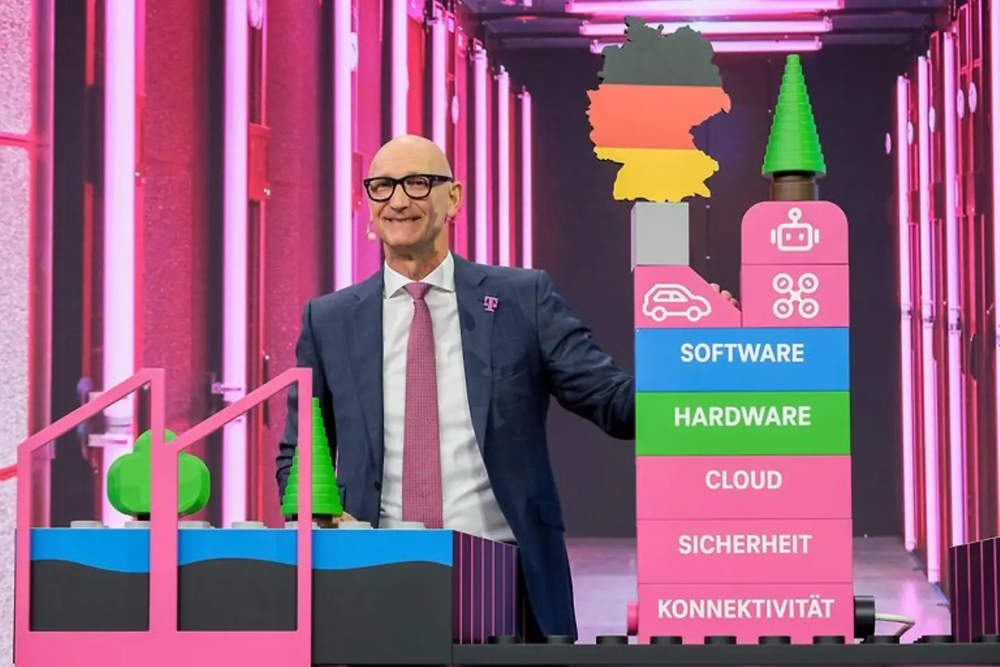 Tim Höttges präsentiert auf der Bühne der Hauptversammlung 2026 ein Modell der KI-Fabrik in München