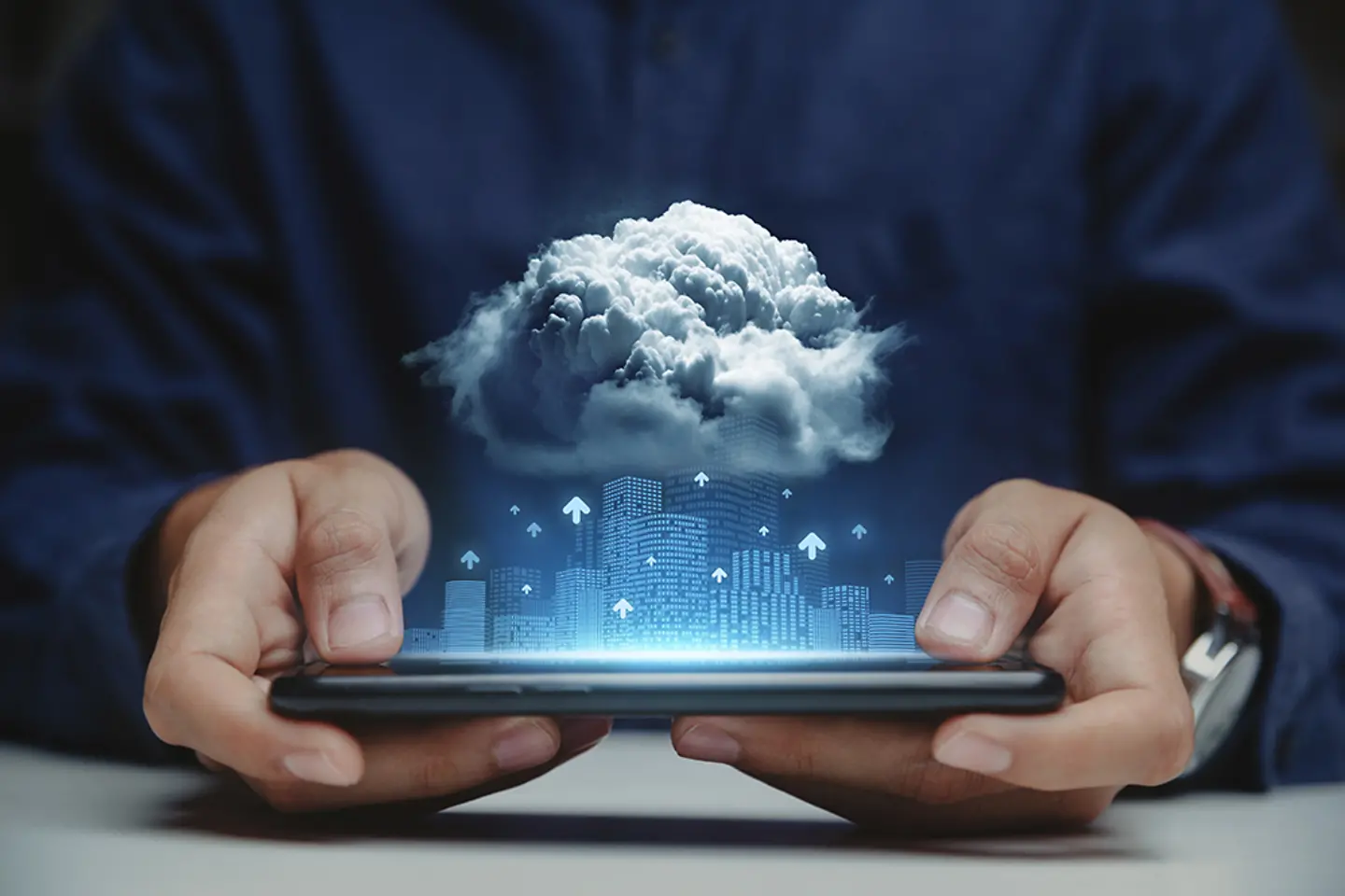 Mann hält Tablet mit Wolkenkratzern und Wolke darüber in der Hand