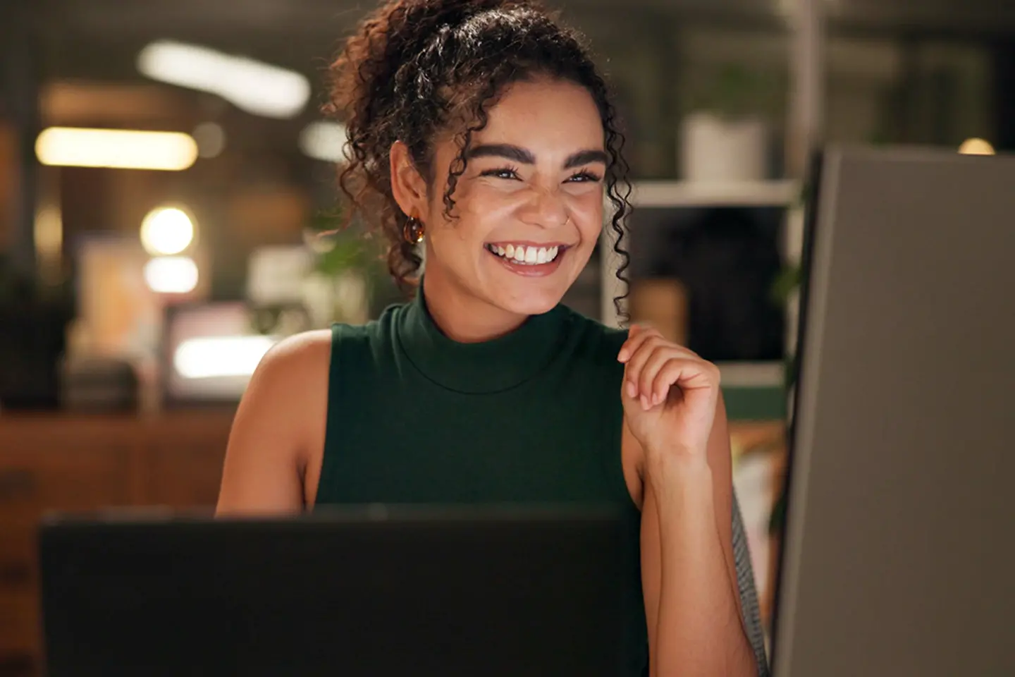 Lachende junge Frau am Computer