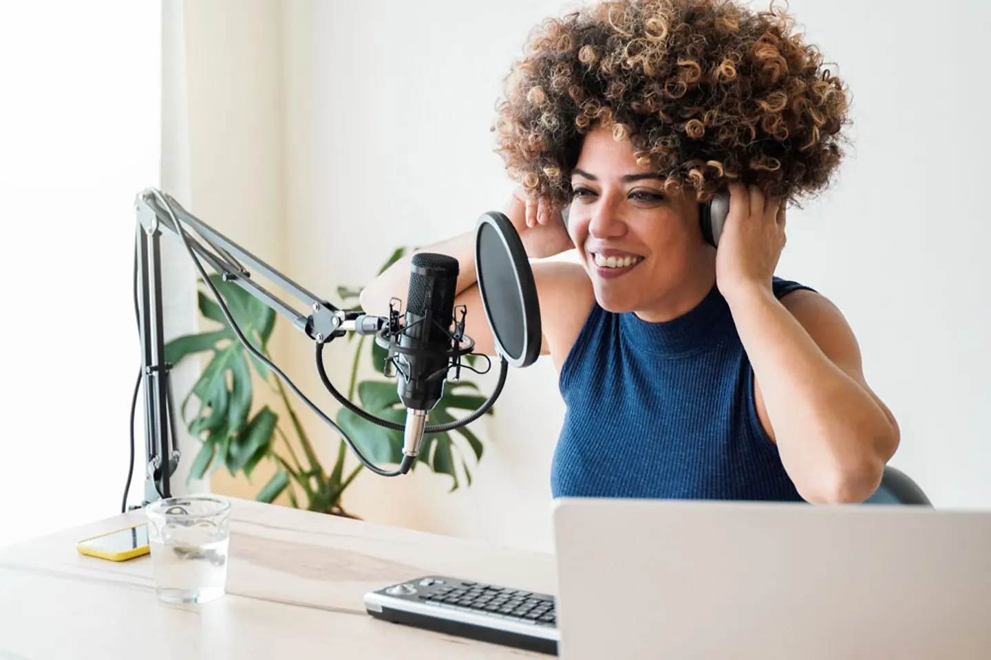 Une femme moderne héberge un podcast depuis un studio au bureau