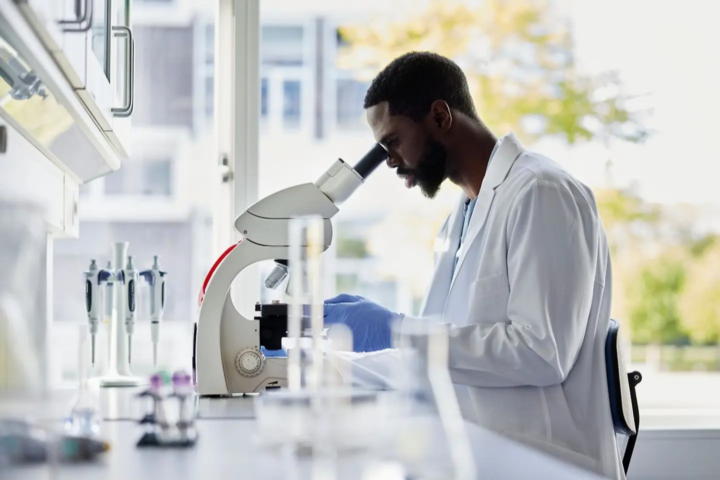 Chemicus bestudeert nieuwe formule onder de microscoop