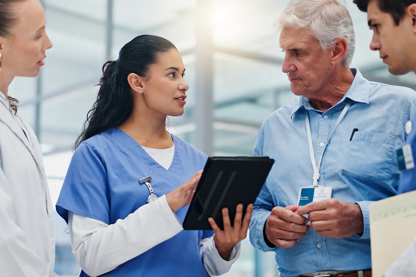 Woman, doctors, and a tablet in a hospital during a team meeting about financing, management, and evaluation."