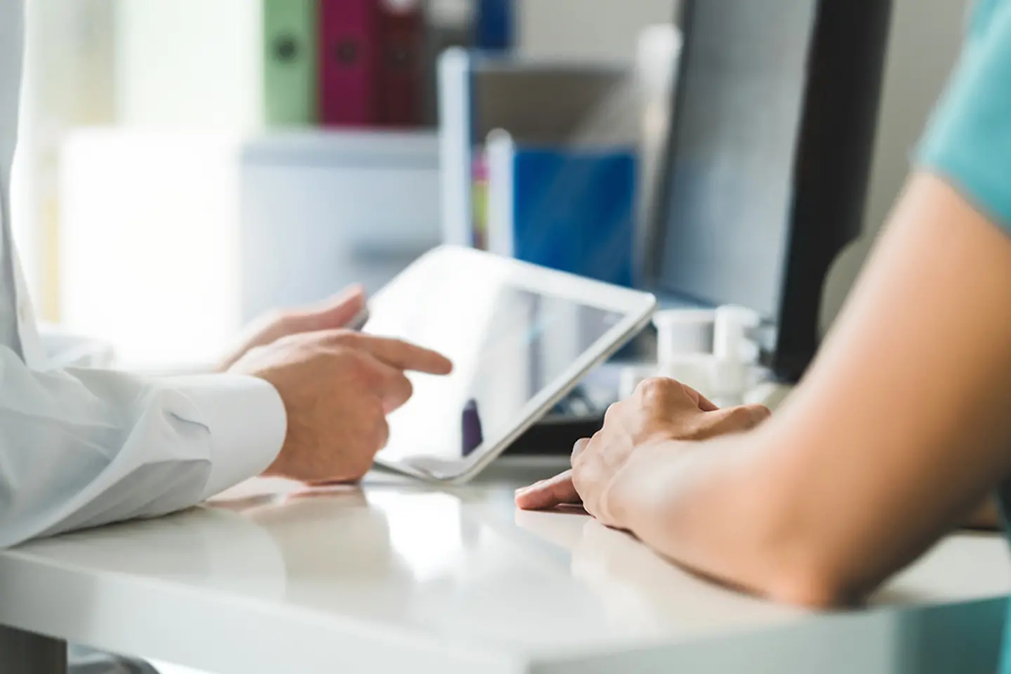 Physician with a tablet in conversation with a patient