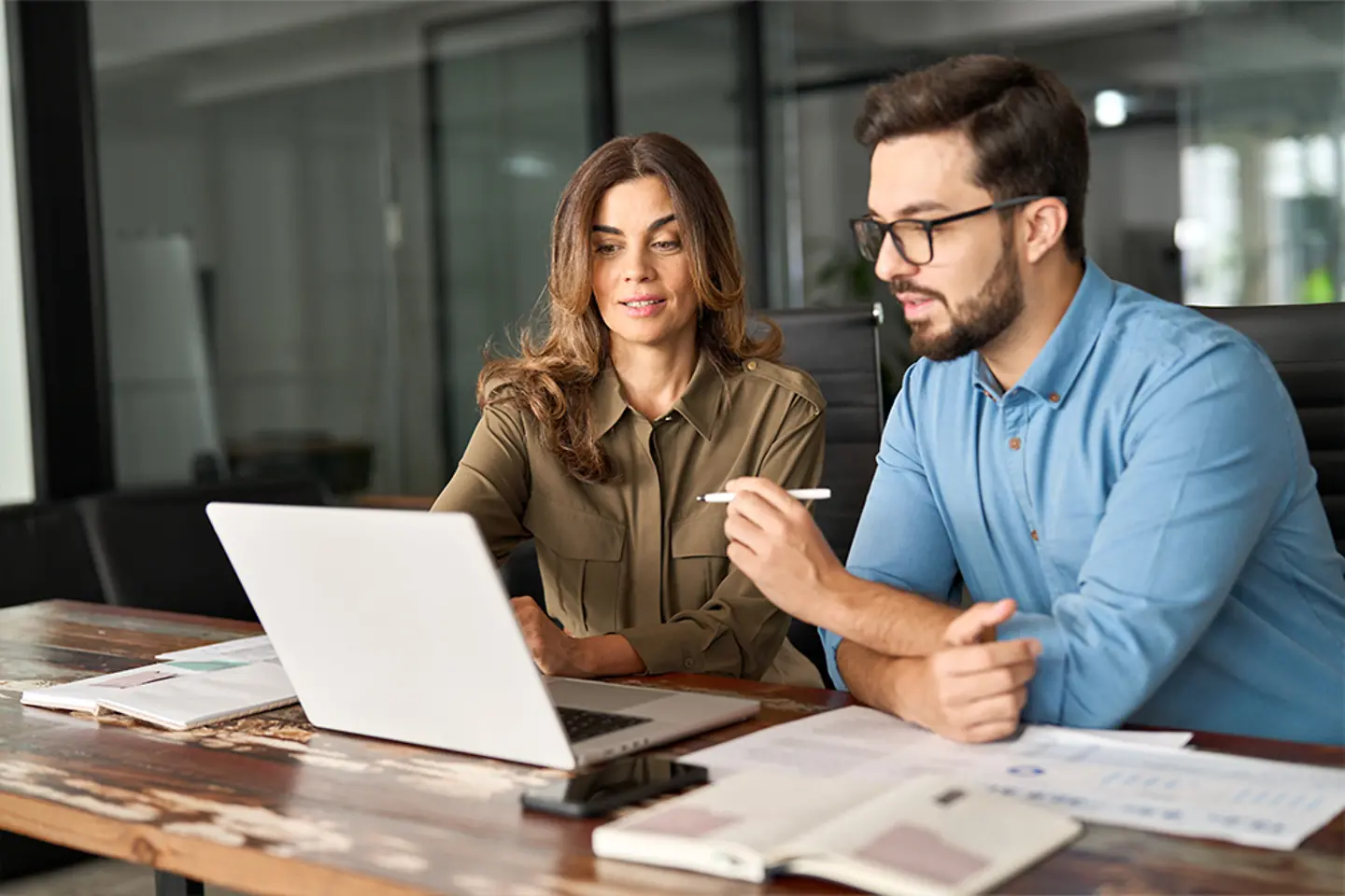 Two colleagues evaluating DevOps offerings on laptop