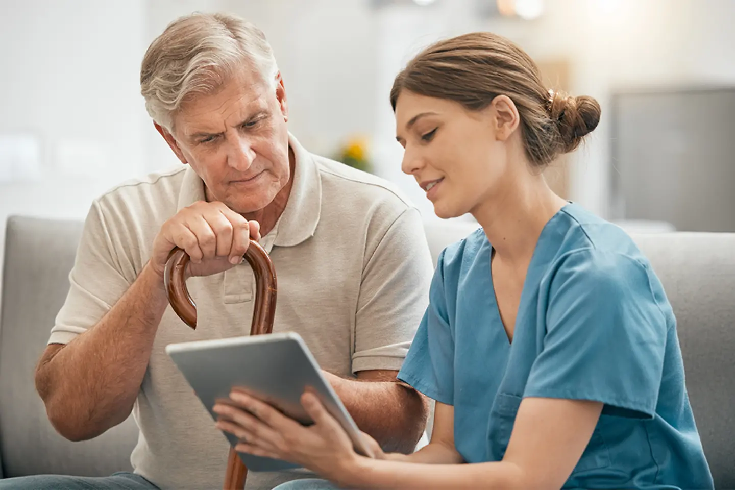 Young nurse showing an older patient his health data
