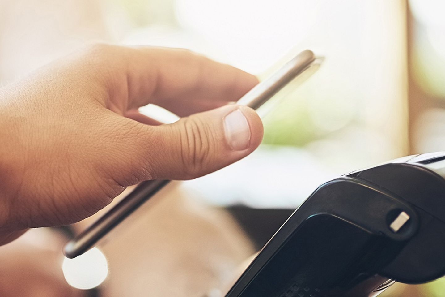 Card reader over which someone is holding their smartphone.