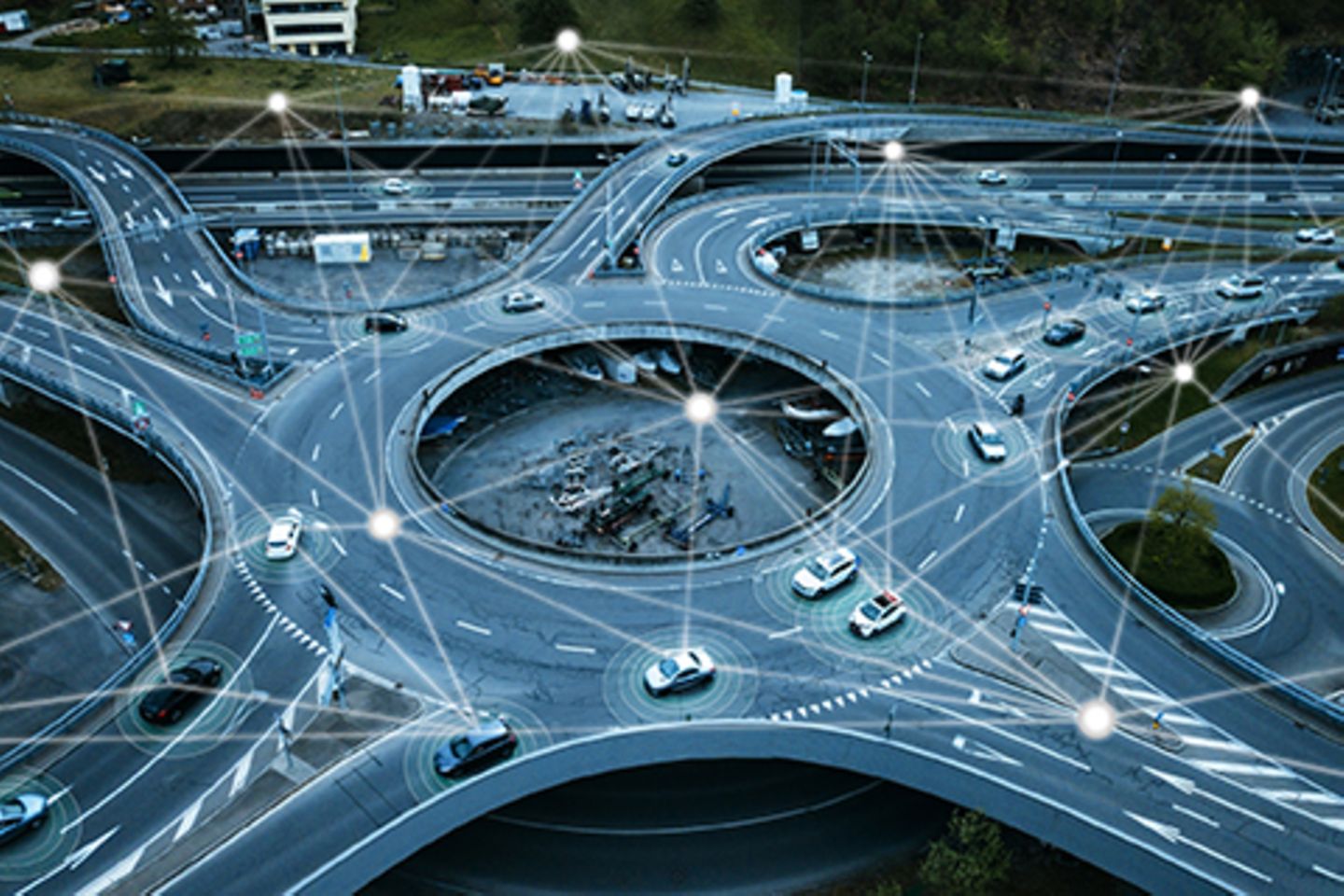 Kreisverkehr von oben, in dem viele Autos fahren die über digitale Netze miteinander verbunden sind. 