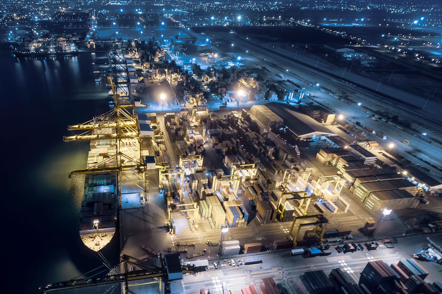 Vista aérea del muelle de embarque tienen un buque portacontenedores y un contenedor por la noche