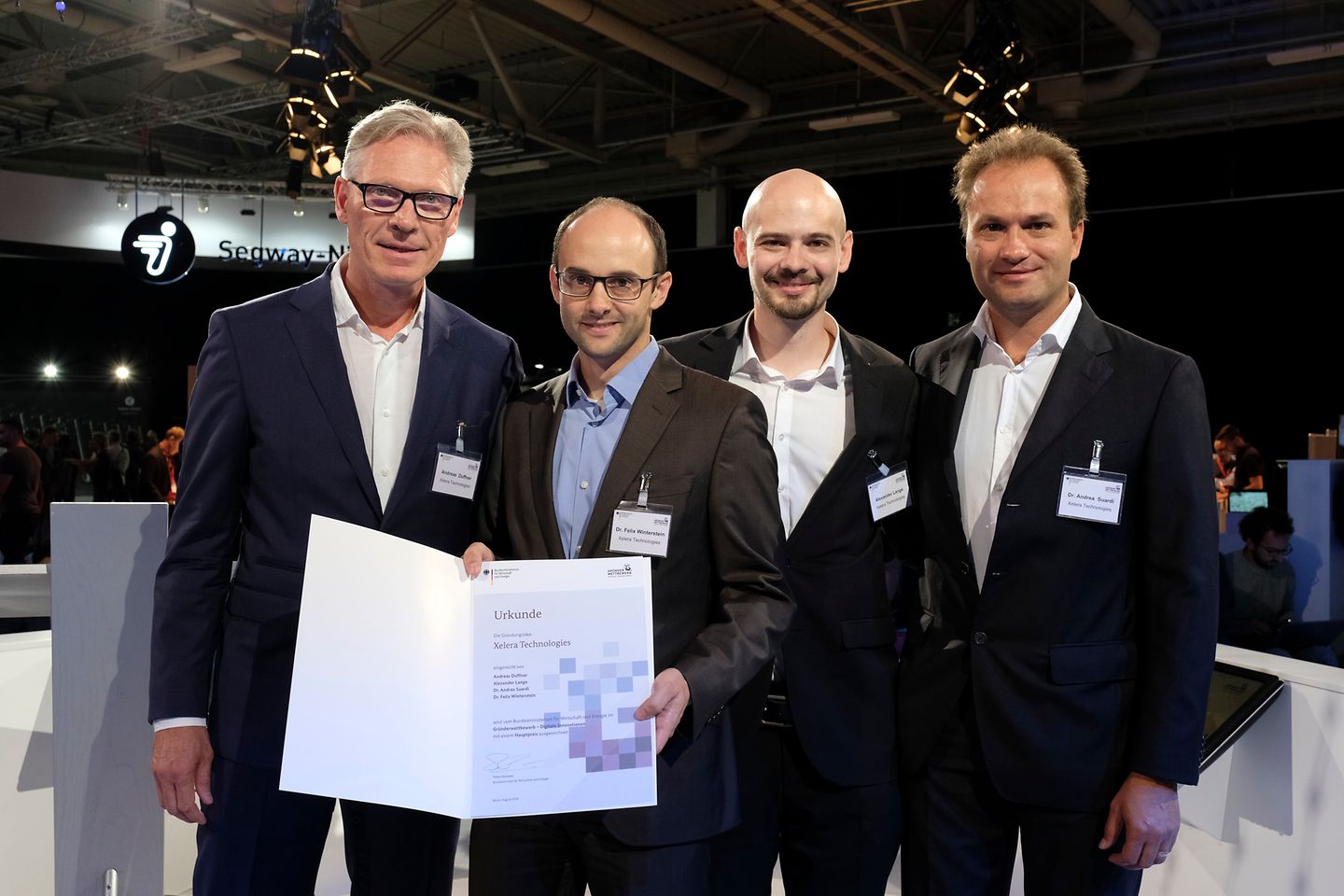 Four men in suits, one holding a deed in his hand.