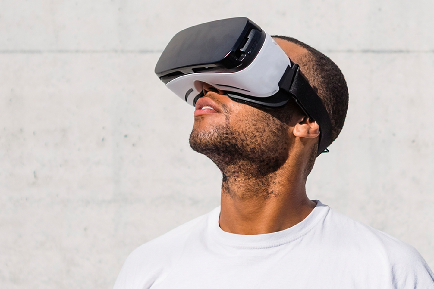 Young man over a concrete wall using a virtual reality headset