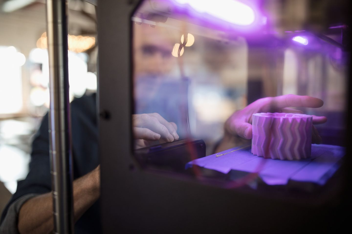 Designer retrieves object from a 3D printer