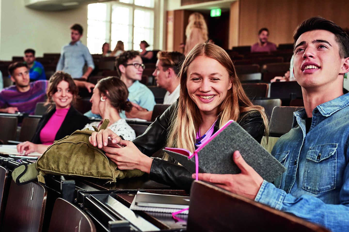 Graduate is sitting in the lecture hall during the lecture