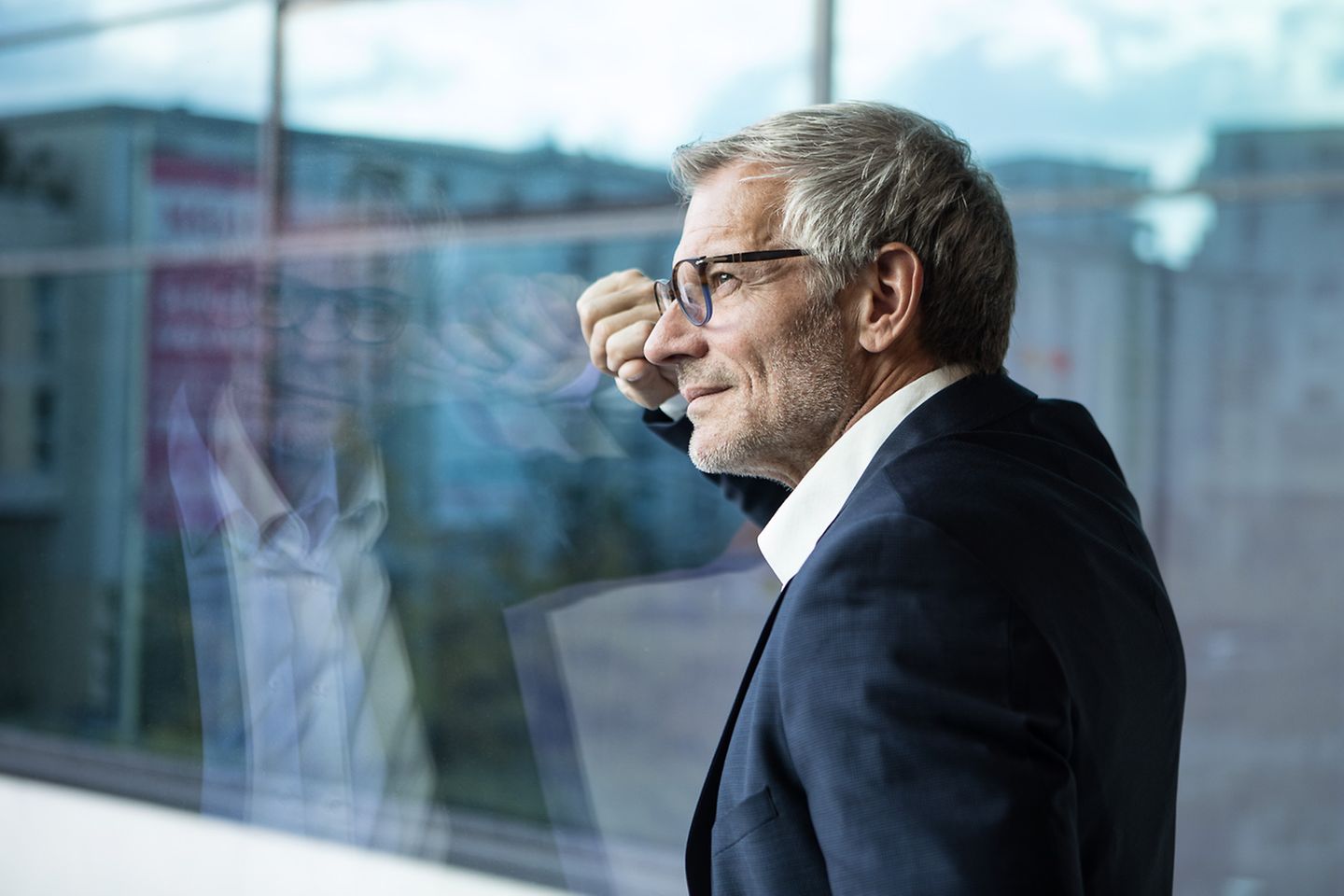 Smiling businessman looks out the window