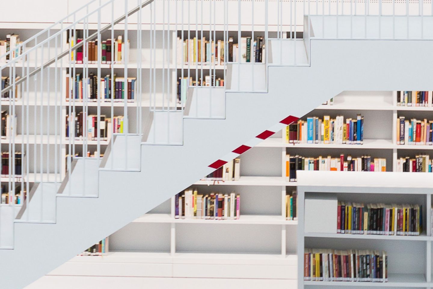 Bright library with many bookshelves and a staircase