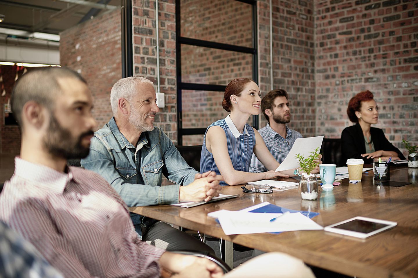 Colleagues sit at a table during a meeting